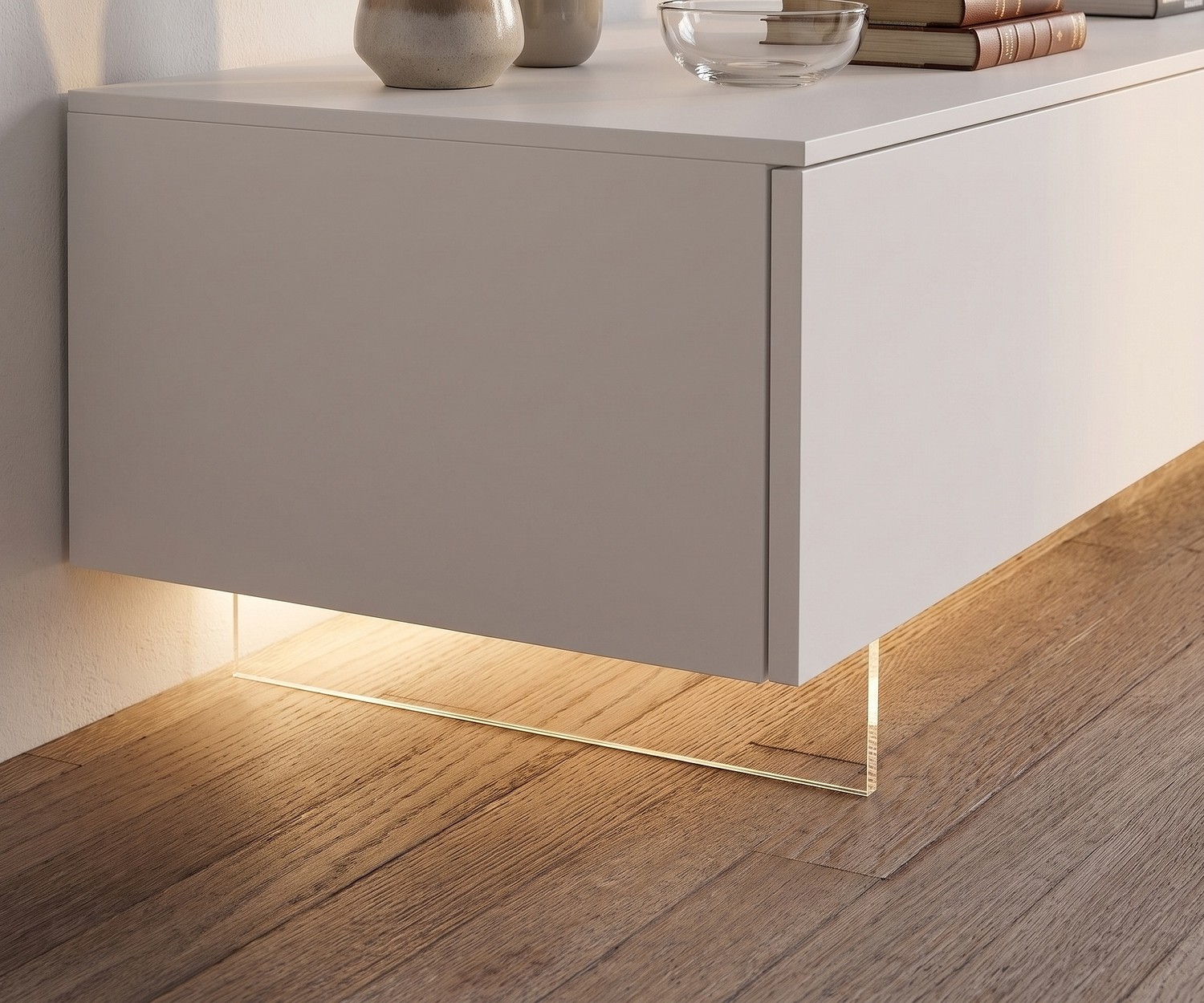 Socle TV transparent Livitalia pour meuble bas Socle TV transparent de Livitalia pour meuble bas suspendu avec éclairage LED sur parquet dans le salon.