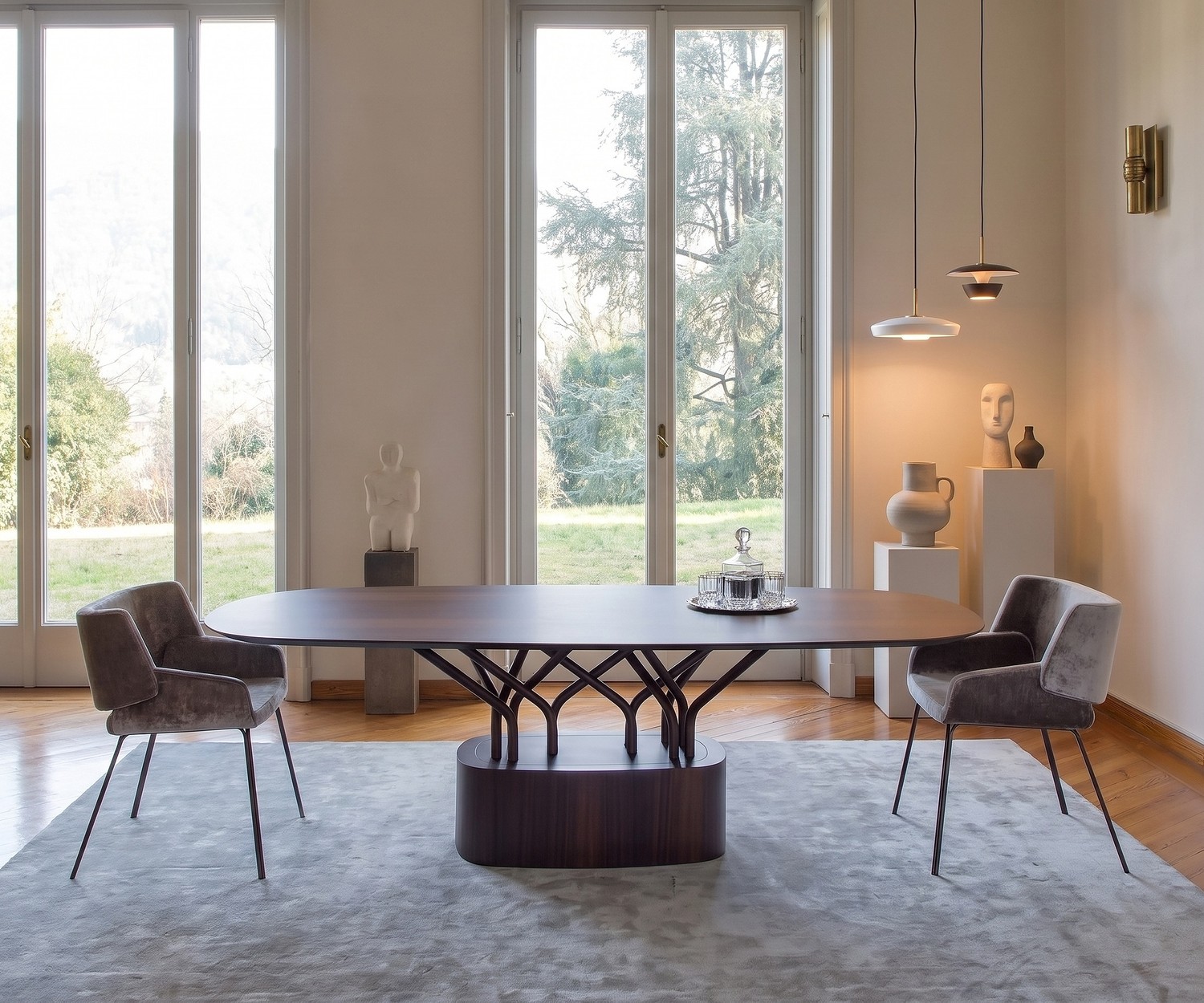 Table à manger ovale al2 wood-oo en bois dans une salle à manger moderne avec chaises en velours gris.