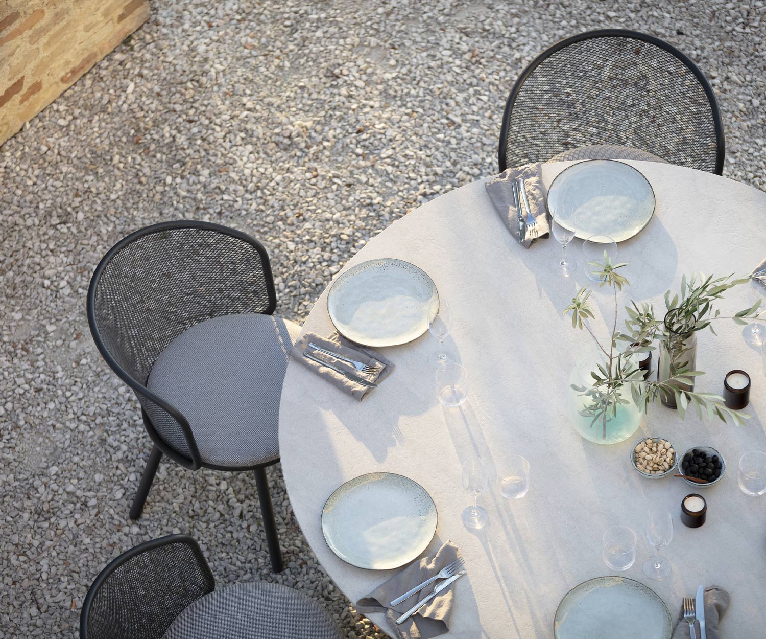 Chaise à accoudoirs Baza de Todus sur la terrasse à la table de jardin vue d'en haut Chaise à accoudoirs Baza de Todus sur la terrasse à la table de jardin vue d'en haut