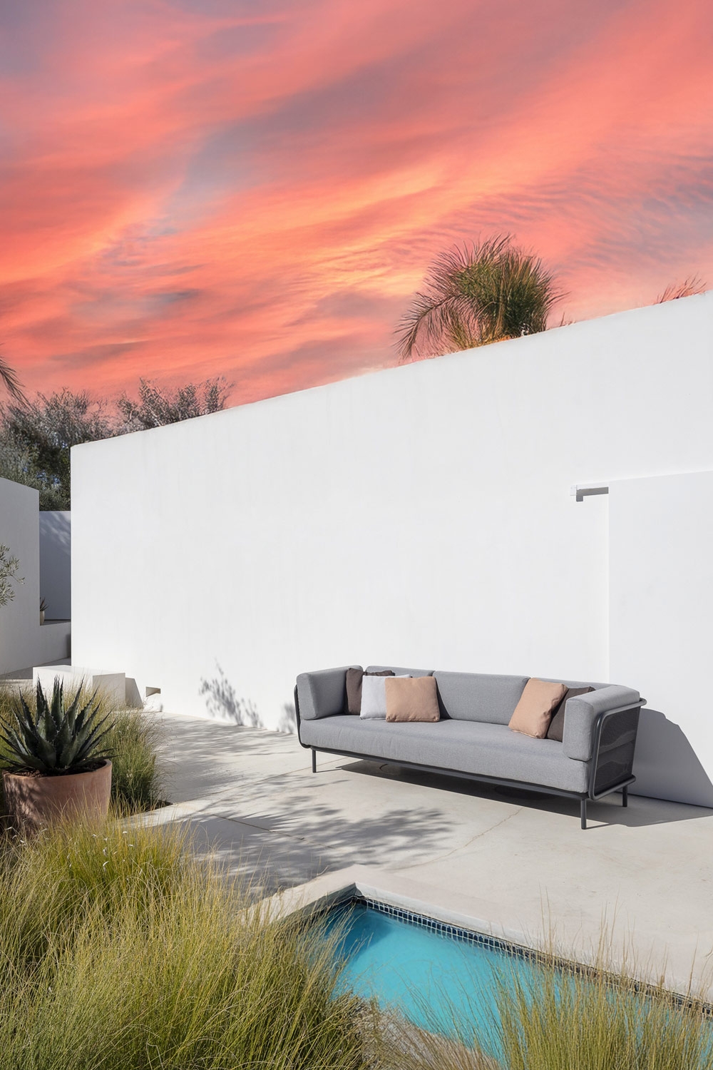 canapé-confortable-au-design-minimaliste-avec-coussins-de-dossier-ronds-sur-une-terrasse-aménagée-à-la-méditerranéenne-avec-piscine