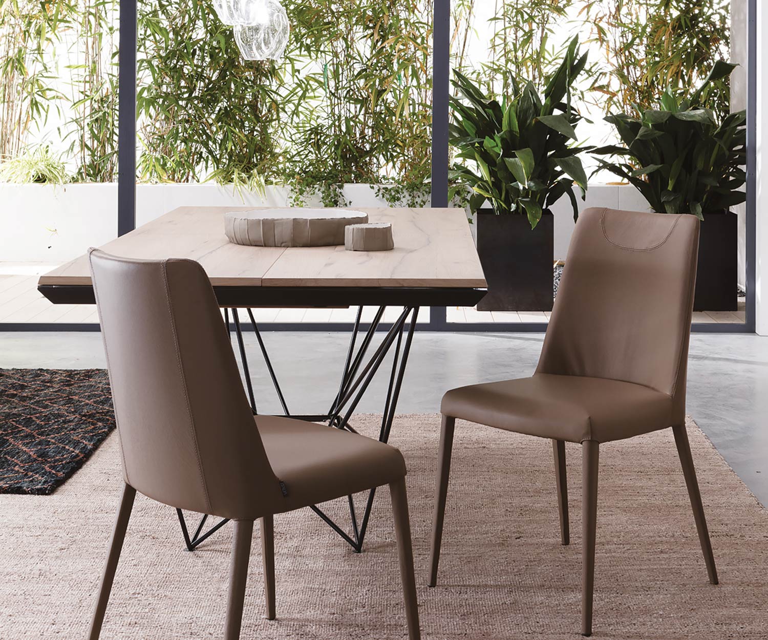 Table de salle à manger design et moderne avec vue sur le piètement de la table en noir brillant Table de salle à manger design et moderne avec vue sur le piètement de la table en noir brillant