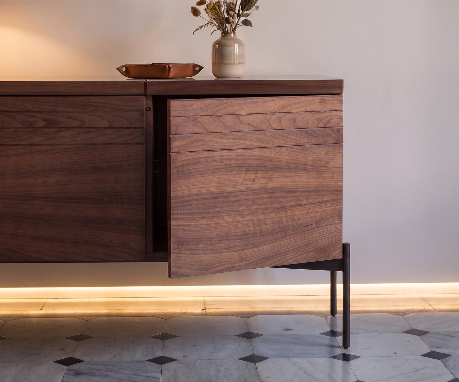 Buffet design al2 o-rizon 003 en noyer Buffet design al2 o-rizon 003 en bois de noyer avec porte push-pull entrouverte pour un salon moderne.