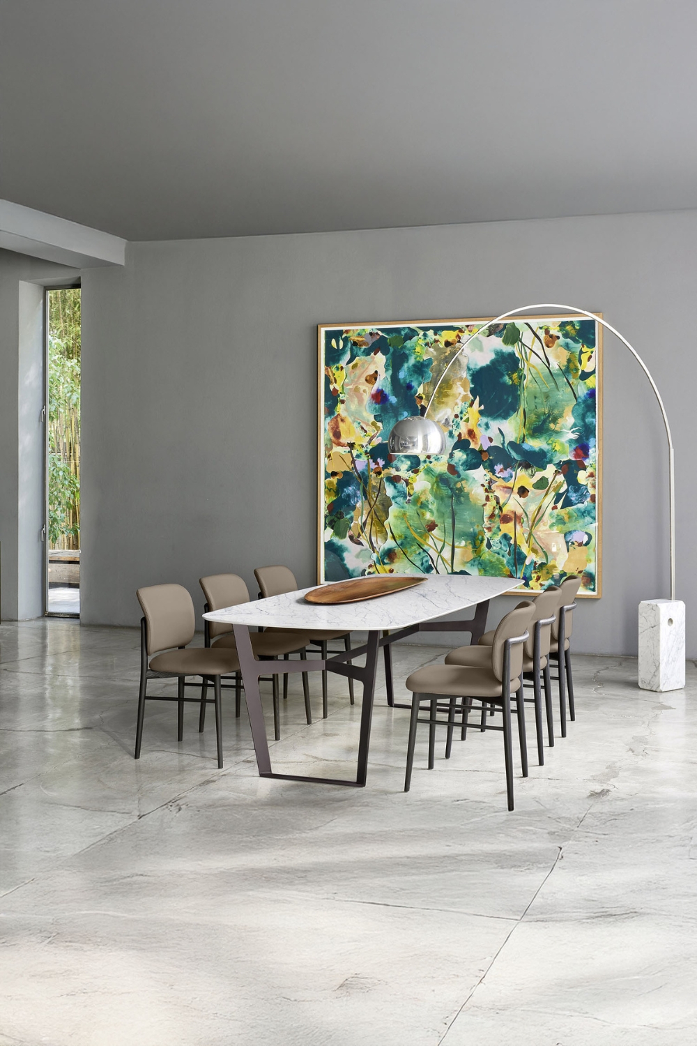 grande salle &agrave; manger carrel&eacute;e avec un ensemble de table &agrave; manger au design minimaliste et une lampe arc devant une peinture murale abstraite color&eacute;e