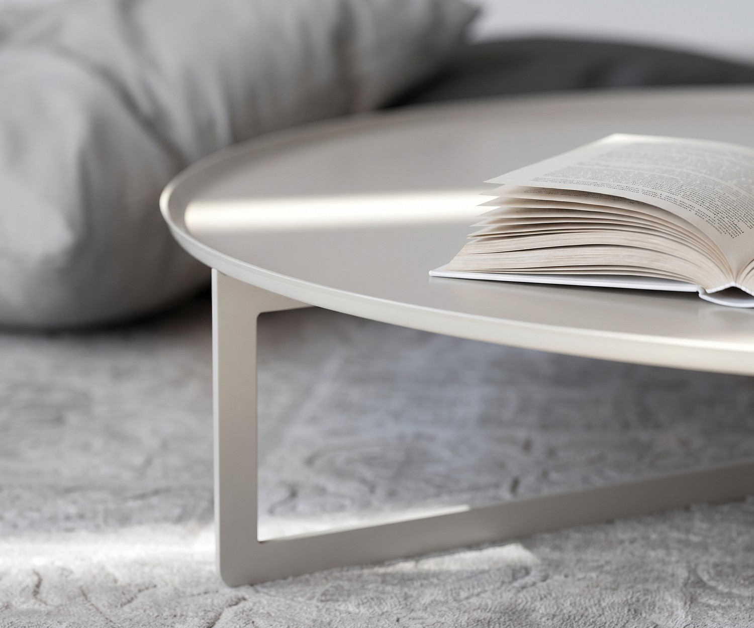 Table basse ronde Round par MEME Design dans un salon moderne. Table design en métal près d'un canapé beige.