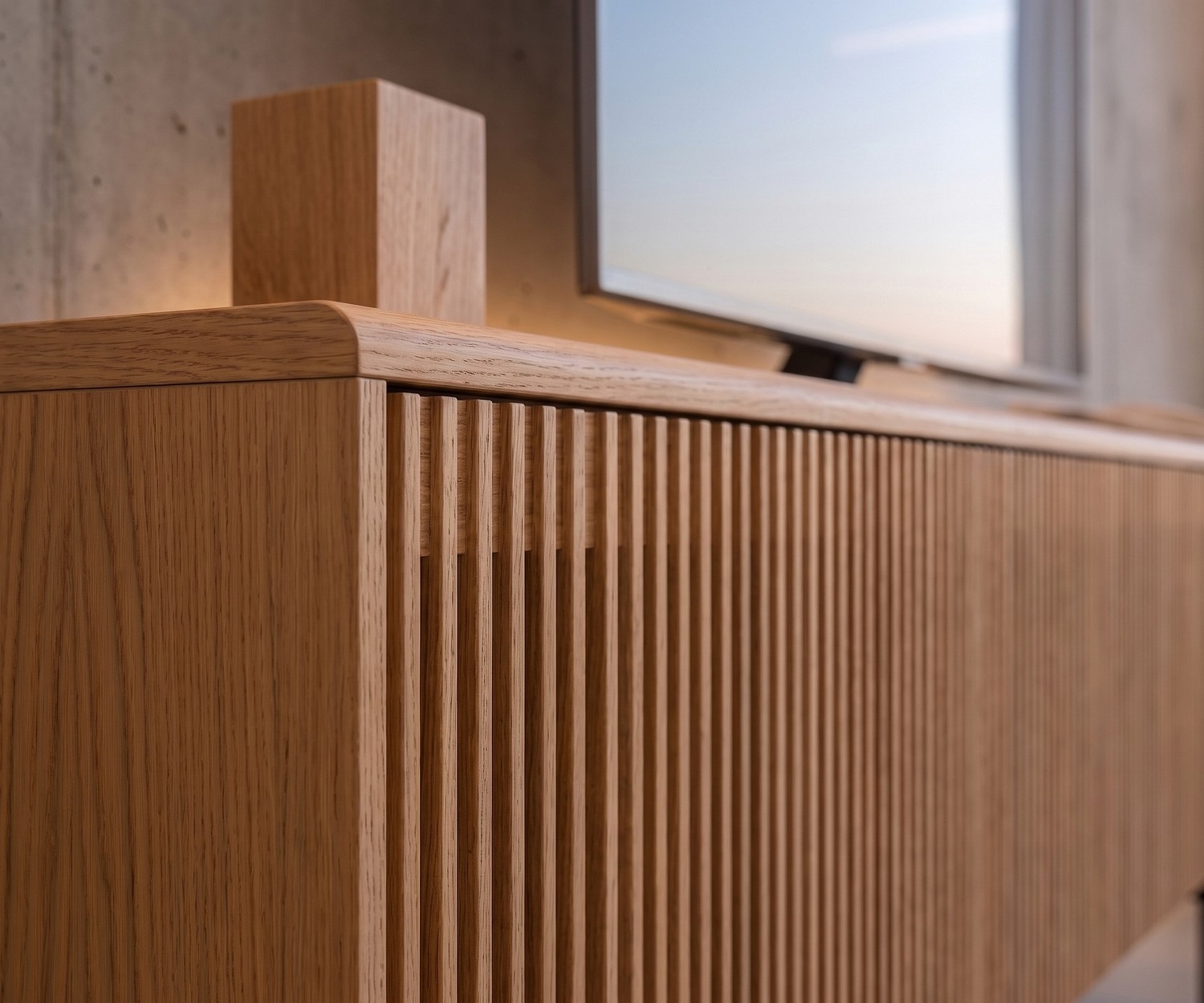 Meuble TV Punt Malmö en chêne pour le salon avec portes à lattes verticales design et bords arrondis élégants.