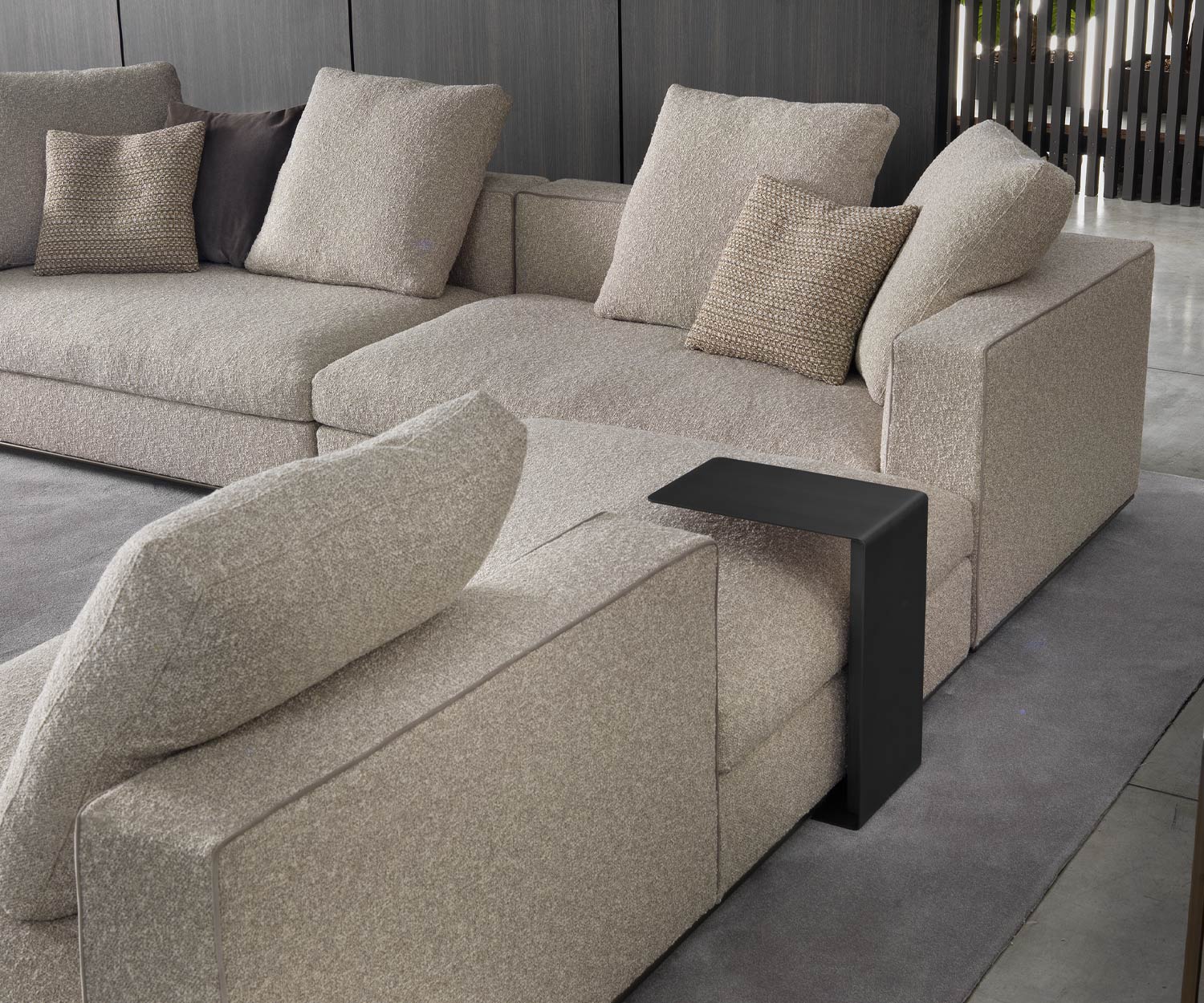 Mini table d'appoint noire de Marelli glissée derrière le canapé Mini table d'appoint noire de Marelli glissée derrière le canapé