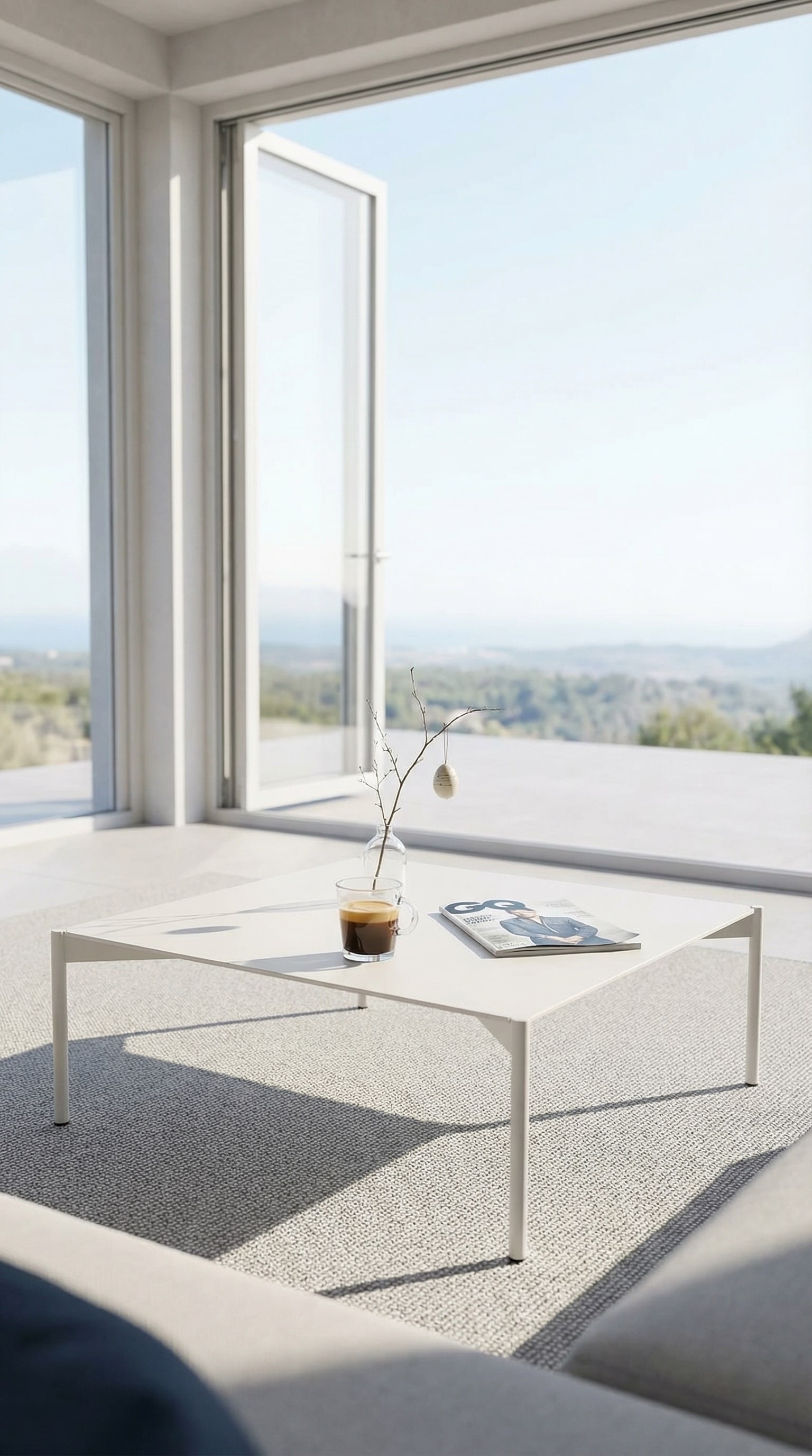 Table basse d'ext&eacute;rieur puriste et plate sur une terrasse ensoleill&eacute;e et lumineuse