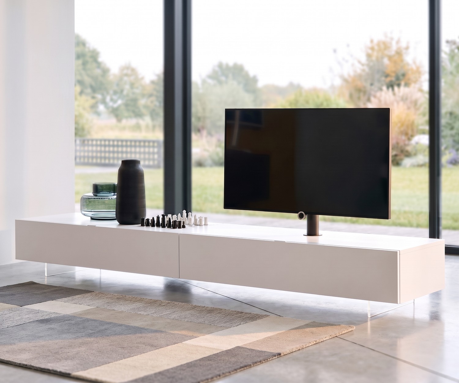 Socle TV transparent Livitalia pour meuble bas Socle TV transparent Livitalia pour meuble bas suspendu dans le salon, design minimaliste en méthacrylate.