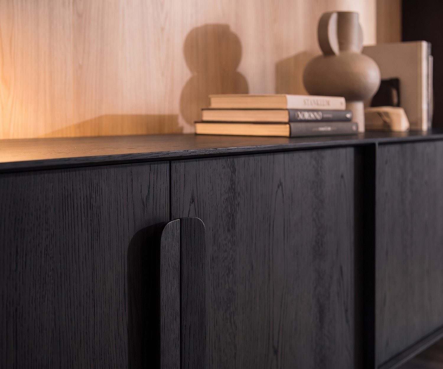 Buffet design Mobius 003 de al2 en placage de chêne noir avec poignées en bois dans un salon moderne.