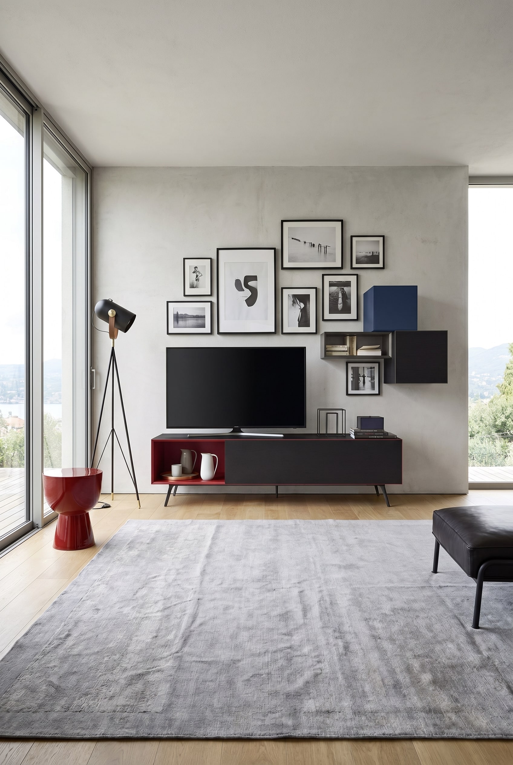 Minimalistisches Lowboard mit offenen roten F&auml;chern und schwarzen Fronten unter einer Wohnzimmer-Galeriewand