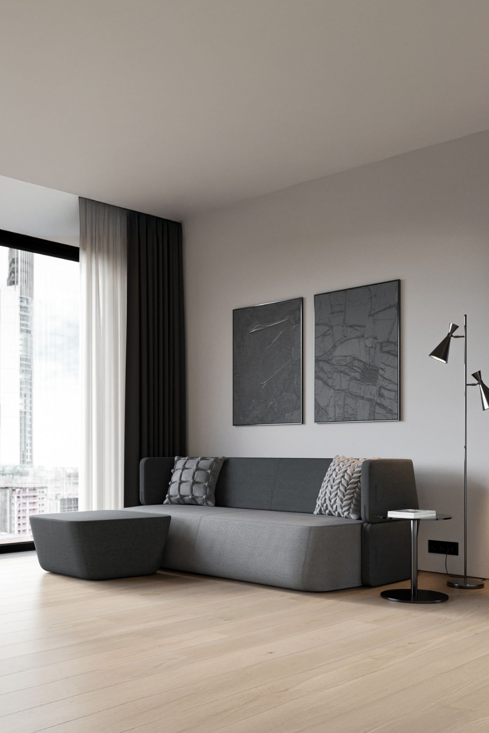 canapé-lit gris aux bords arrondis complété par un pouf assorti et une table d'appoint ronde