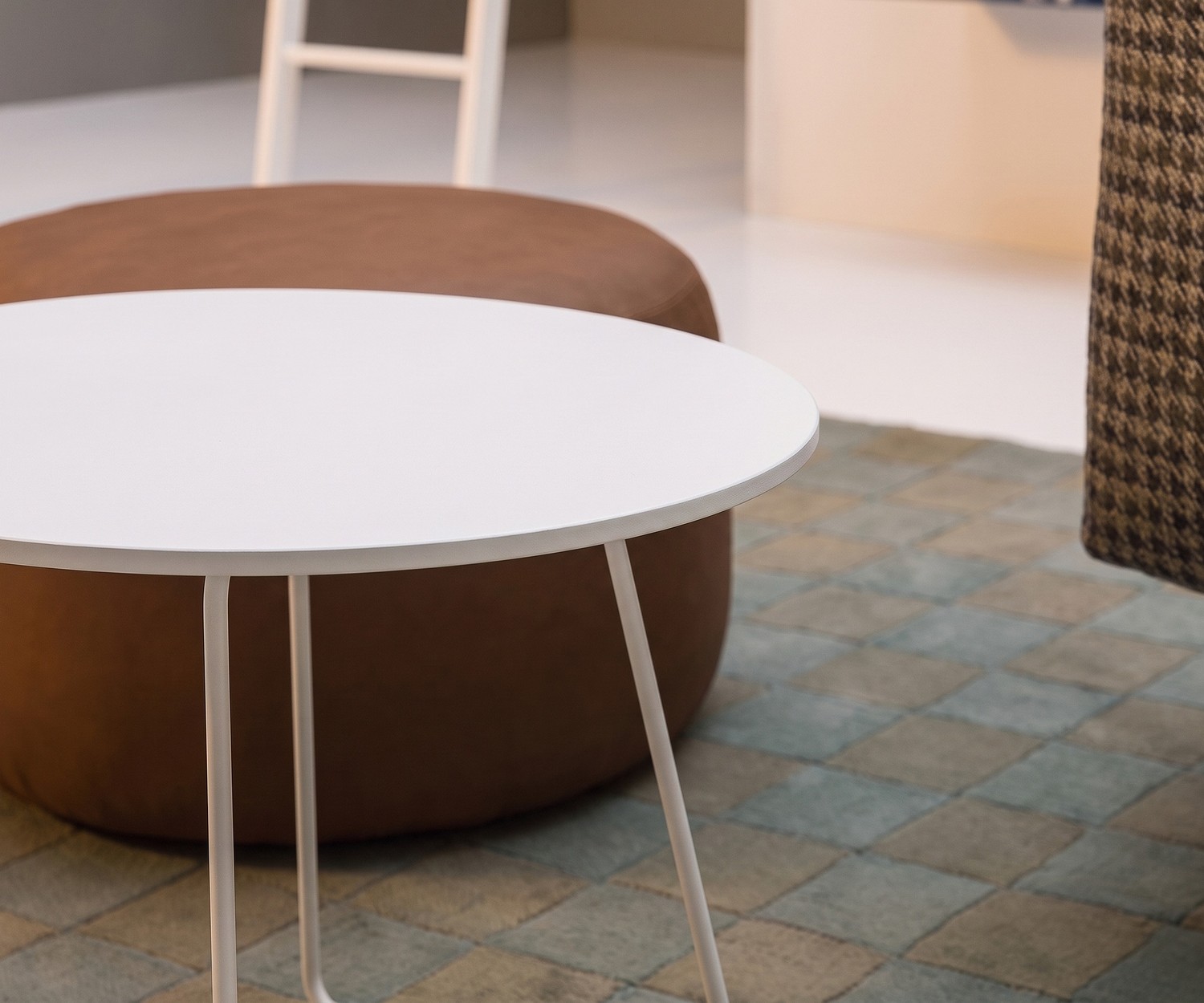 Table basse Novamobili Orbis blanche Table d'appoint Novamobili Orbis dans un salon près d'un pouf marron, table basse ronde blanche design.